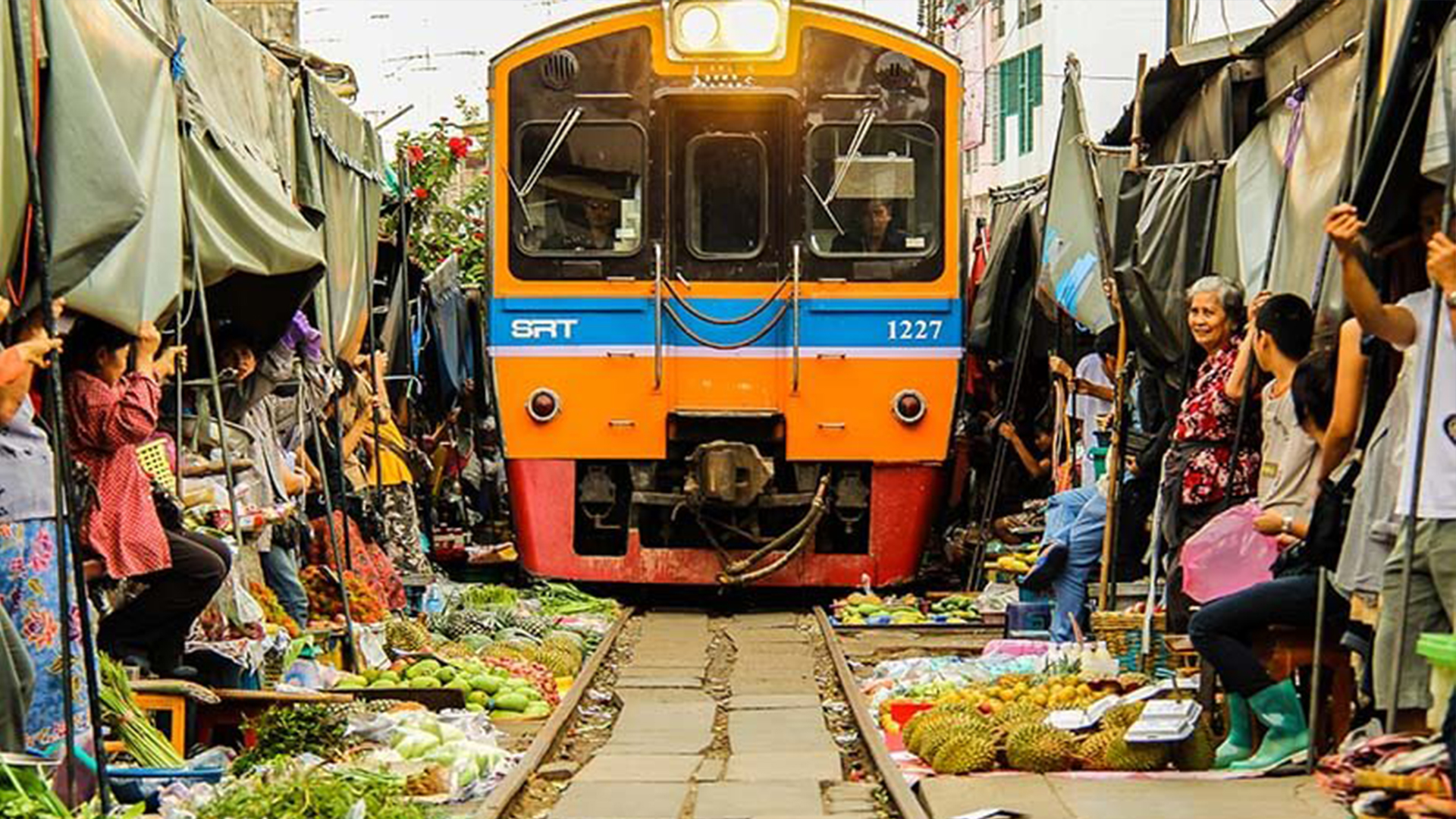 قطاری در تایلند که از داخل بازار عبور می‌کند
